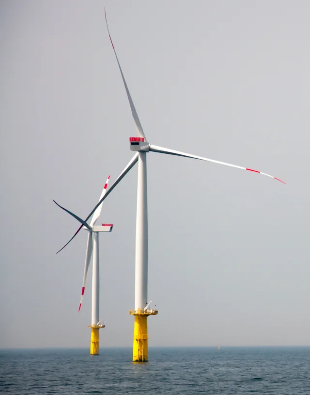 Wind turbines sea against clear sky portrait